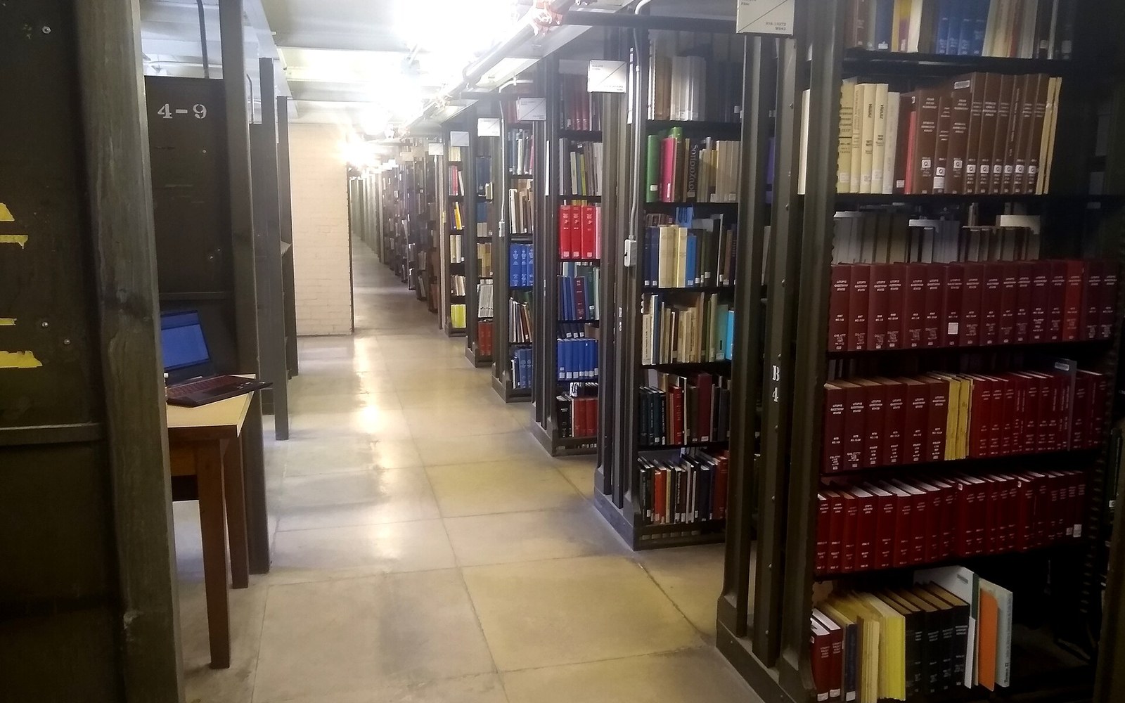 A library stack aisle with shelving running away