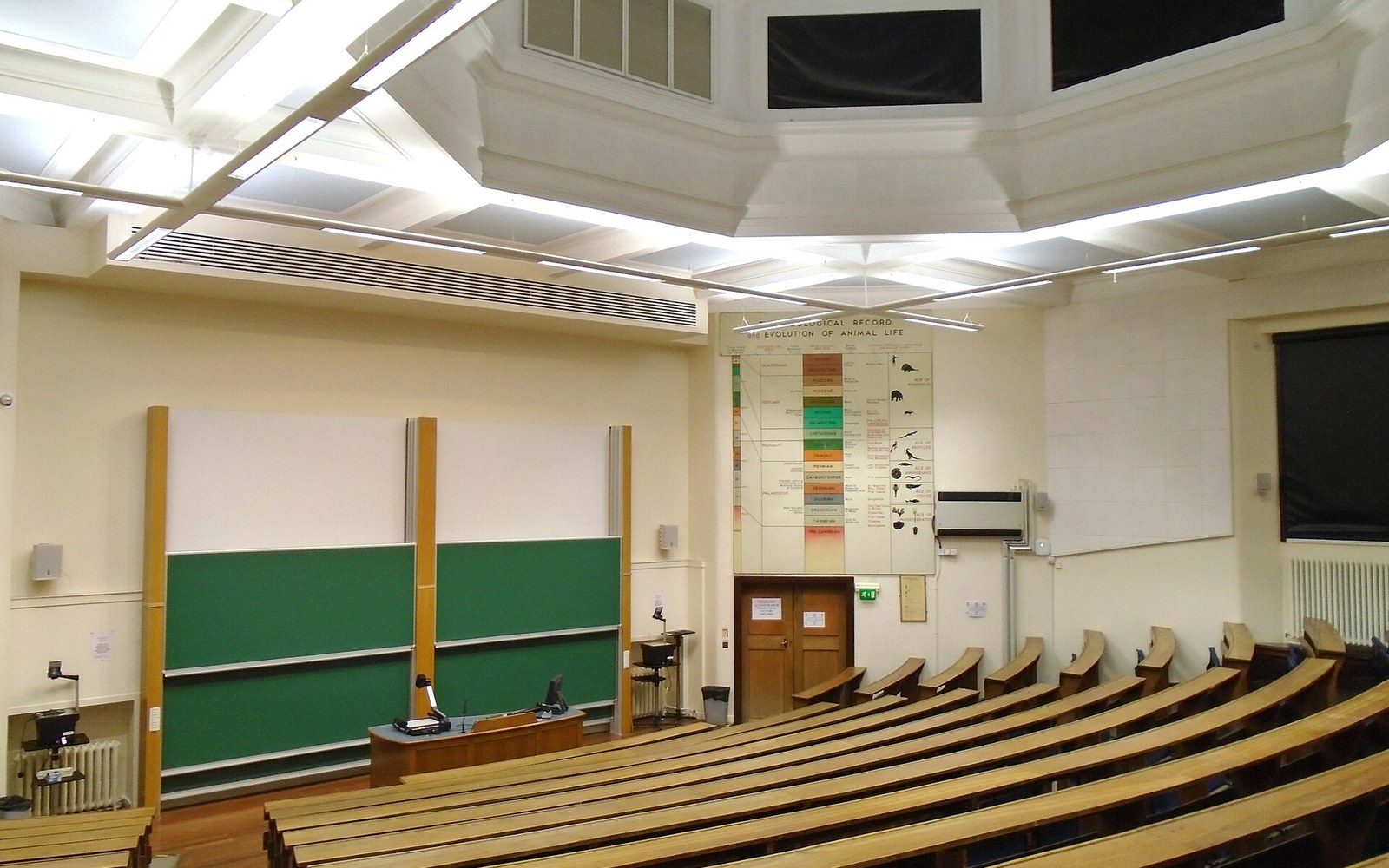 A raked lecture theatre seen from the back, empty